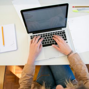 Woman working on laptop with documents